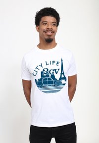 Bílý tričko s modrým grafickým designem vintage auta a Eiffelovy věže, s texty "City Life" a "2cv" v tučném písmu.