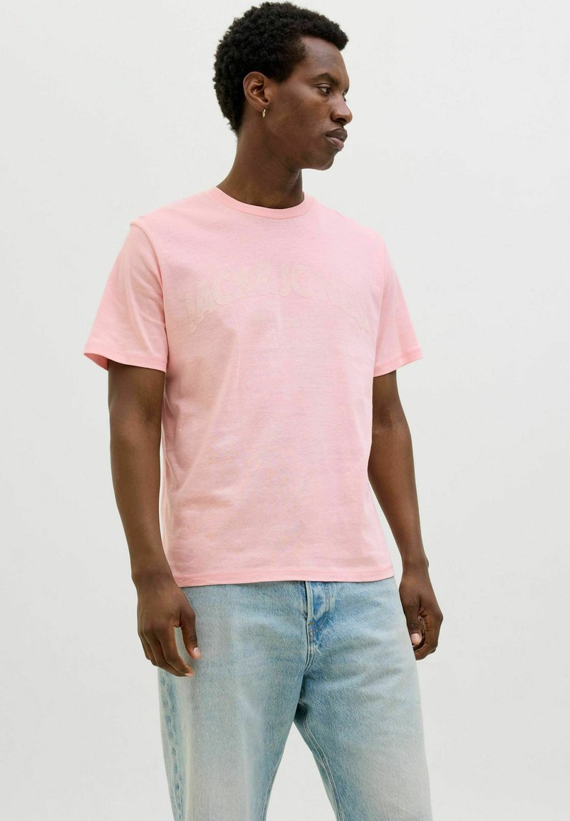 Lichtroze t-shirt van zachte stof, met een ronde halslijn en korte mouwen. "Jack & Jones" logo in een iets donkerdere tint.