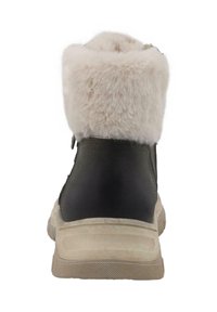 Grøn ydermateriale med beige sål, toppet med en blød, fluffy lysfarvet krave. Har en lynlås på siden for nem påtagning.