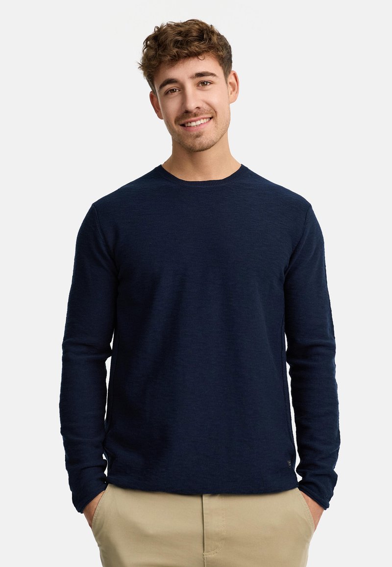 Maglietta a maniche lunghe di colore blu navy in un morbido tessuto a maglia, con scollo rotondo e polsini a coste. Il design presenta un orlo dritto e un sottile dettaglio con logo.