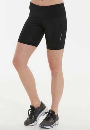 Sorte atletiske shorts med høj talje, glat tekstur og længde til midten af låret, parret med mørke løbesko med mesh-overdel.
