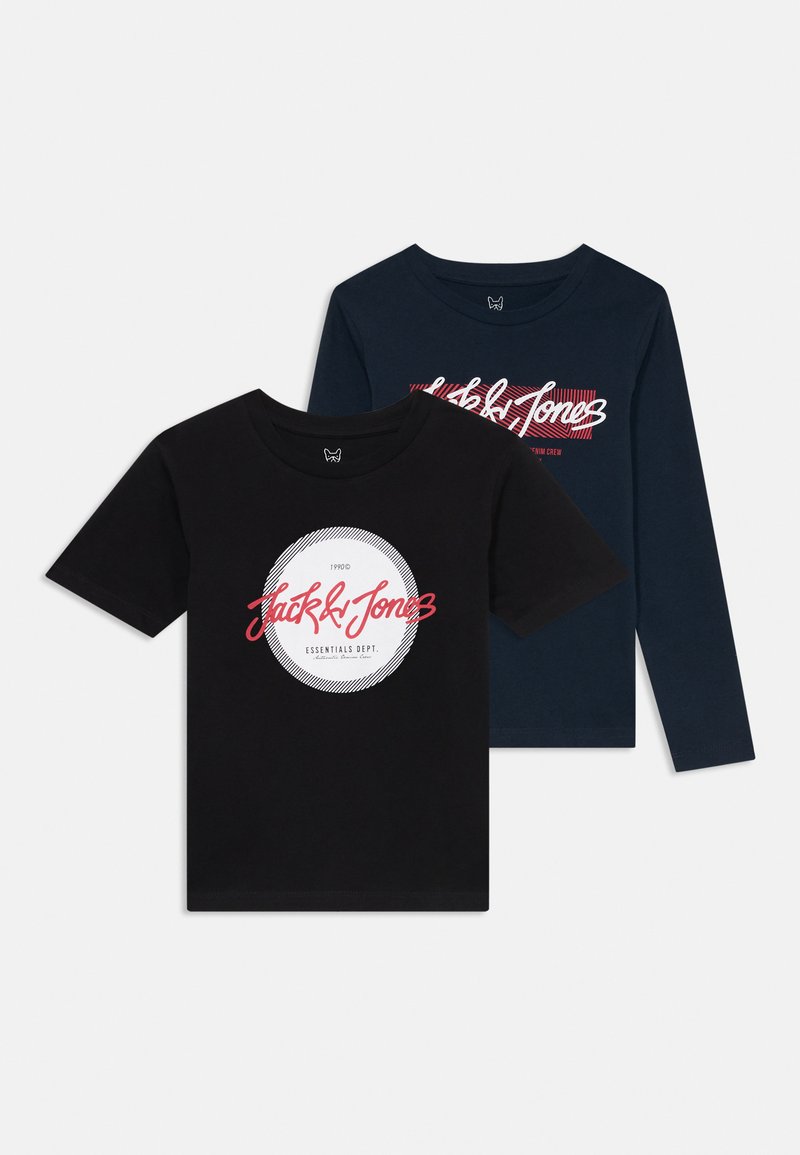 Dos camisetas apiladas: una negra con un logo circular y texto, y una azul marino con letras en blanco y rojo en negrita.