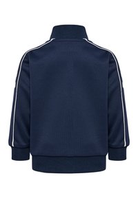 Veste de sport bleu marine avec un col haut, des rayures blanches sur les côtés et des poignets et un ourlet côtelés. Tissu doux avec une texture lisse.