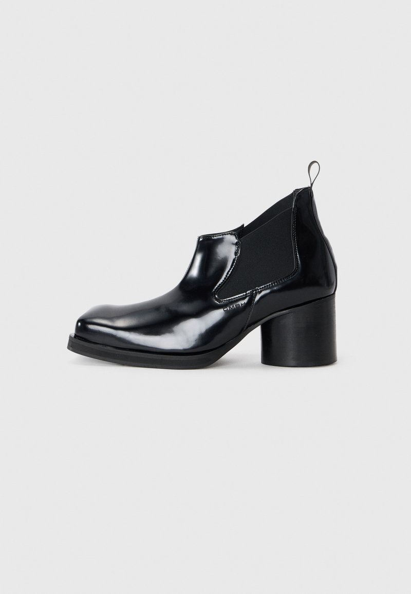 Μαύρη πατεντε leather μπότα μέχρι τον αστράγαλο με χοντρό τακούνι, ελαστικές πλευρικές πάνελ, στρογγυλή μύτη και θηλιά πίσω για εύκολη φόρεμα.