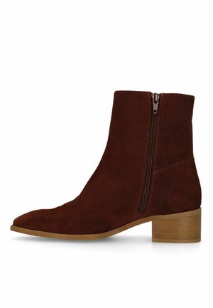 Bottine en daim marron avec fermeture éclair latérale et petit talon bloc en bois sur fond blanc.