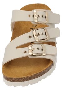 Weiße Riemensandalen mit drei verstellbaren Riemen, goldenen Schnallen und einem Korkfußbett. Sanfte Wildledertextur auf der Innensohle.
