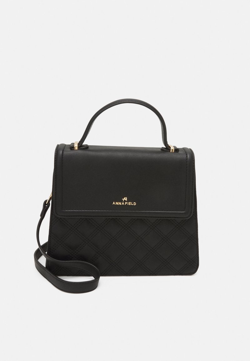 Black quilted leather handbag with a top handle and detachable shoulder strap. Gold logo detail on front. Rectangular shape with structured design.