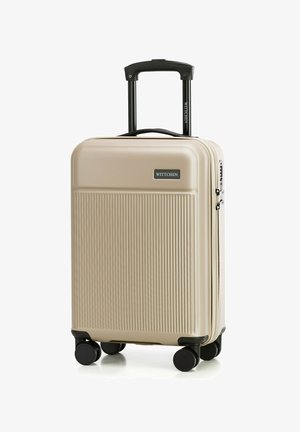 Valise rigide beige avec un motif à rayures verticales, roues noires et poignée rétractable. Présente une étiquette de logo à l'avant.