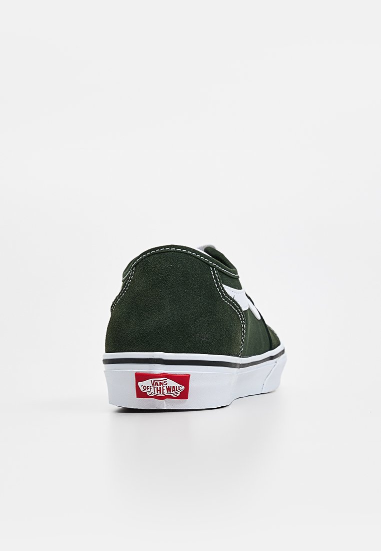 Baskets en suède vert avec des accents blancs, au design classique, et un logo Vans rouge sur le talon. Détails cousus le long des coutures.