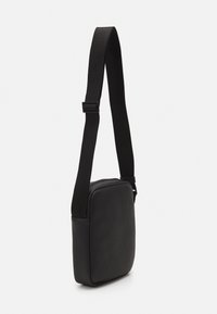 Borsa a tracolla nera in pelle con forma rettangolare, caratterizzata da una superficie texture, cinturino regolabile e senza hardware o dettagli visibili.