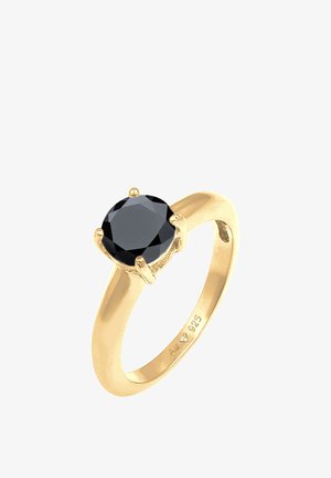 Anillo de oro con una gran piedra negra redonda, facetada y engastada en un soporte de cuatro garras con una banda lisa. Marcado 925 en el interior.