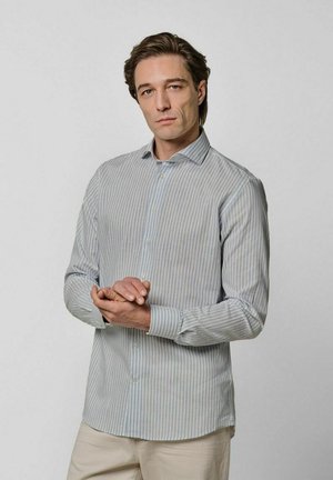 Camisa de vestir con rayas azul claro y blancas, abotonada con cuello puntiagudo, mangas largas y dobladillo curvo. La tela parece suave.