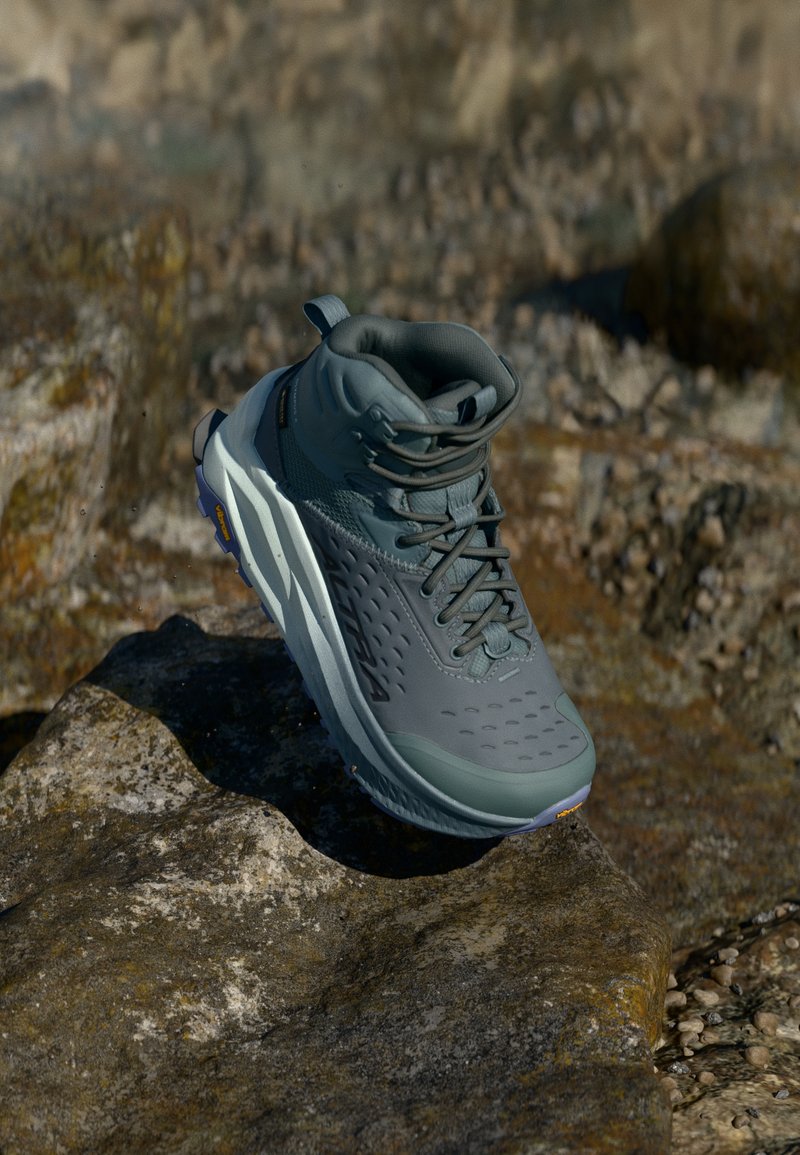 Bota de caminhada leve e impermeável, na cor cinza, com parte superior texturizada, design de atacadores e sola acolchoada com um padrão de rasto para aderência.
