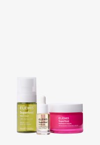 Trois produits de soins de la peau ELEMIS Superfood : un flacon pulvérisateur vert, un compte-gouttes transparent, et un pot de crème rose, chacun étiqueté avec le nom des produits.
