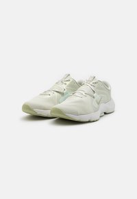 White athletic shoes with light green accents, mesh upper, textured surfaces, and a padded collar. Features a lace-up design and logo detail.