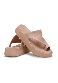 Sandales compensées en caoutchouc rose avec bout ouvert et une sangle épaisse et texturée sur le dessus du pied, présentant un design moderne et minimaliste.