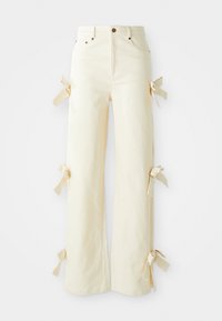 Pantalones de mezclilla color crema con un corte de pierna ancha. Presentan lazos a los lados, cinco bolsillos y un cierre de botón clásico.