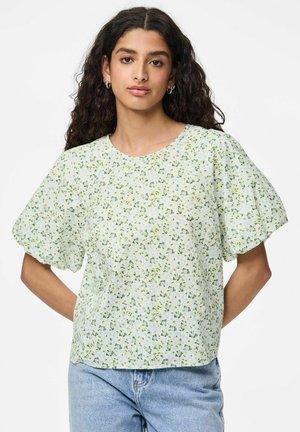 Blouse florale en vert clair avec des manches courtes bouffantes. Fabriquée en tissu léger, elle arbore un col rond et des motifs de petites fleurs dispersés.