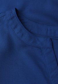 Blåt stof med en glat tekstur, der har en rundet halsudskæring og synlige stingdetaljer, hvilket fremhæver et rent og minimalistisk design.