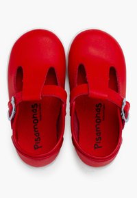 Scarpe in pelle rossa con punta arrotondata, aperture sui lati e una fascia regolabile con una fibbia in argento. Interno morbido.