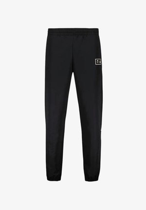 Pantalons de sport noirs en tissu lisse et léger. Dotés d'une taille élastique et d'un petit patch logo sur le côté supérieur gauche.