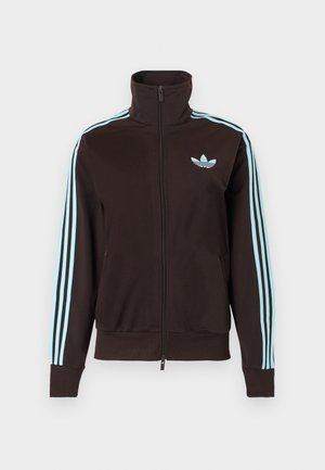 Fekete cipzáras szabadidődzseki, világoskék Adidas logóval a mellkasnál és három világoskék csíkkal minden ujján.