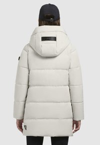 Cappotto bianco imbottito con cappuccio removibile, caratterizzato da un'etichetta nera sul retro, vestibilità leggermente sfiancata e un logo sul lato inferiore.