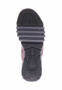 Zwarte rubberen zool met textuurpatronen en richels, voorzien van een bordeauxrode stoffen bovenkant. Flexibel ontwerp met gripaccenten voor tractie.