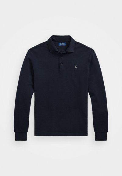 Jūras spēku zila garenroku polo krekls, izgatavots no kokvilnas, ar divu pogu aizdari, ribotu apkakli un aprocēm, un mazu izšūtu logo uz krūtīm.