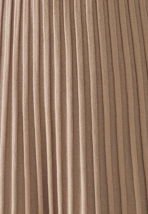Plissé stof in een zachte beige kleur, met verticale strepen die een textuur aan het oppervlak geven. Het materiaal lijkt lichtgewicht en glad.