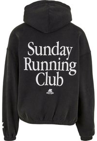 Felpa nera con la scritta "Sunday Running Club" in grandi lettere bianche sul retro e un piccolo logo "Another Cotton Lab" sottostante.