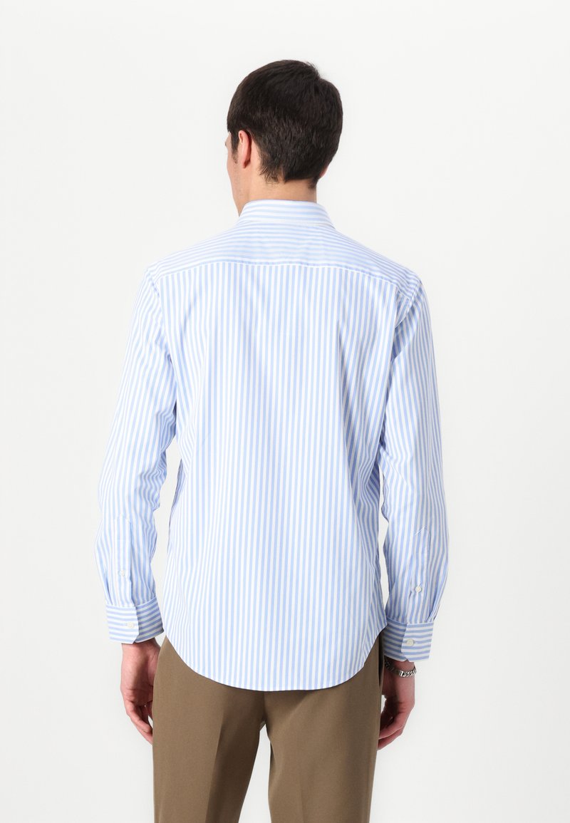 Chemise à manches longues bleu clair et blanche à rayures, en tissu coton, col boutonné, ourlet arrondi, avec des poignets boutonnés et un détail au dos.