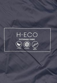 Marineblauer Stoff mit glatter Textur zeigt weißen Text und Icons, die "H-ECO", "Nachhaltiger Stoff", "Umweltfreundlich" und "Wasserabweisend" anzeigen.