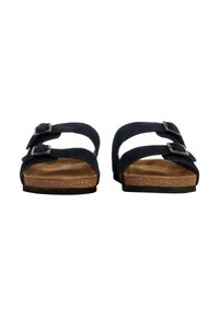 Sandales en suede noir avec deux sangles réglables, boucles en argent et semelle en liège. Semelle plate légèrement texturée, design épuré.