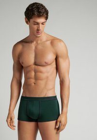 Boxer shorts de algodón verde para hombre con un diseño ajustado. Presenta una cinturilla en contraste y costuras planas para mayor comodidad y durabilidad.