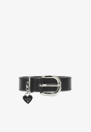 Cintura in pelle nera con fibbia rotonda in argento e ciondolo a forma di cuore in argento pendente, inciso con la scritta "GUESS girl", su sfondo bianco.
