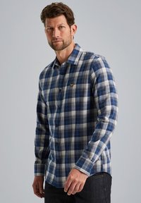 Blauw en wit geblokt overhemd van gestructureerde stof, met een knoopsluiting aan de voorkant en een enkele borstzak met logo-detail.