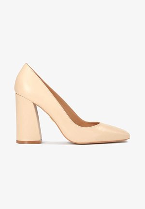 Beige leren high-heeled pumps met een spitse neus en een chunky hak. Gladde textuur met subtiele stikdetails op de bovenkant.