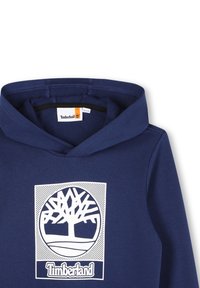 Felpa blu navy con tasca a marsupio frontale. Presenta un grande logo bianco dell'albero Timberland e testo. Tessuto morbido con cappuccio regolabile.