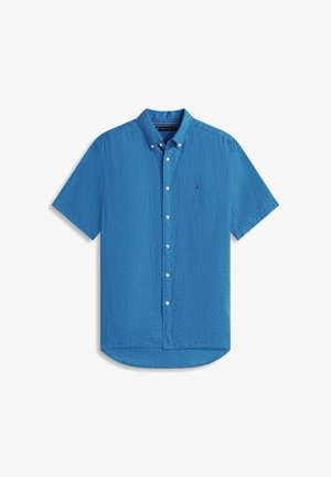 Chemise bleu à manches courtes avec boutons, col boutonné et petit logo sur la poitrine, présentée sur un fond blanc.