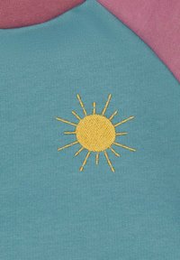 Katoenen shirt in teal met een roze halslijn, met gele zonborduring in het midden. Gladde textuur en casual ontwerp.