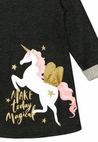 Schwarzes Kleid mit einem weißen Einhorn-Graphic, das eine rosa Mähne, goldene Akzente und den Text "MACHE den heutigen Tag magisch" in goldener Schrift zeigt. Silberne strukturierte Manschetten.