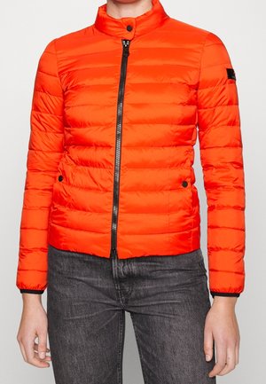 Doudoune orange vif avec col montant, design matelassé horizontal, fermeture éclair à l'avant et accents noirs ; légère et résistante à l'eau.