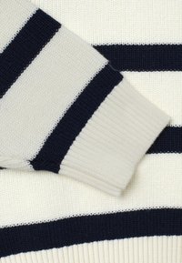 Strickpullover mit abwechselnden cremefarbenen und marineblauen horizontalen Streifen, strukturiertem Stoff und gerippten Bündchen für eine enganliegende Passform.