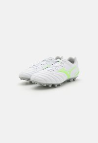 Scarpini da calcio bianchi con tomaia testurizzata, con dettagli verde neon e suola grigia. Design con lacci e numerosi tacchetti per la trazione.