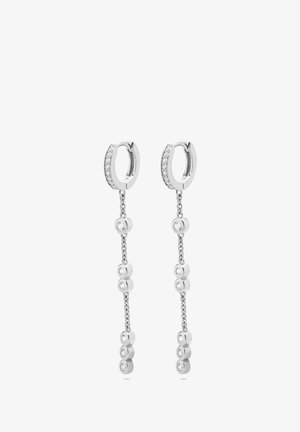 Boucles d'oreilles en argent en forme de créole avec une chaîne pendante ornée de pierres claires rondes et d'une finition polie. Texture lisse et design symétrique.