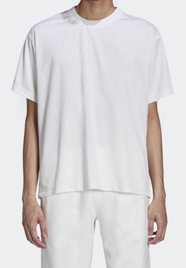 Bílý krátký rukáv tričko vyrobené z jemné tkaniny, s kulatým výstřihem, uvolněným střihem a jemným texturovaným vzorem. V kombinaci s světlými kalhotami.