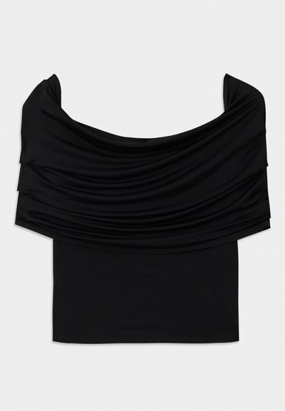 Černý top bez ramínek s přehnutou tkaninou, měkkou strukturou a přiléhavým střihem. Disponuje hladkým, minimalistickým lemem v oblasti pasu.