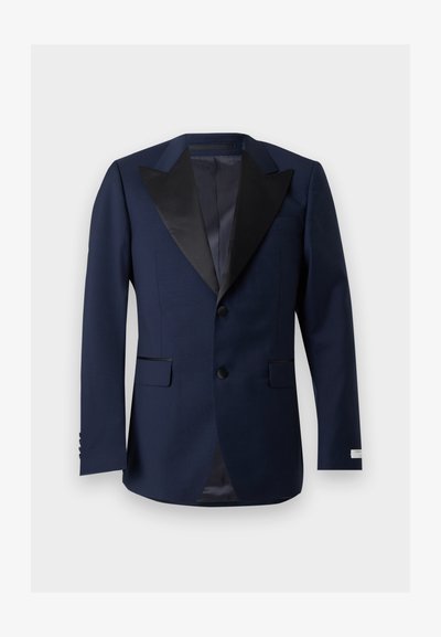 Σκούρο μπλε σακάκι tuxedo με μαύρους σατινέ αιχμηρούς γιακάδες, δύο εμπρόσθια κουμπιά, τσέπες με καπάκι και μανσέτες με τέσσερα κουμπιά, απεικονισμένο σε λευκό φόντο.