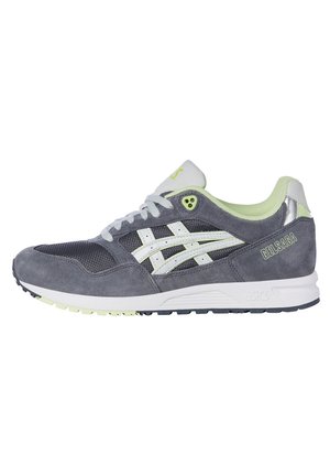 Baskets ASICS GEL-SAGA gris et vert clair avec lacets blancs, dessus en mesh et en daim, et semelle marquée, montrées de profil latéral.